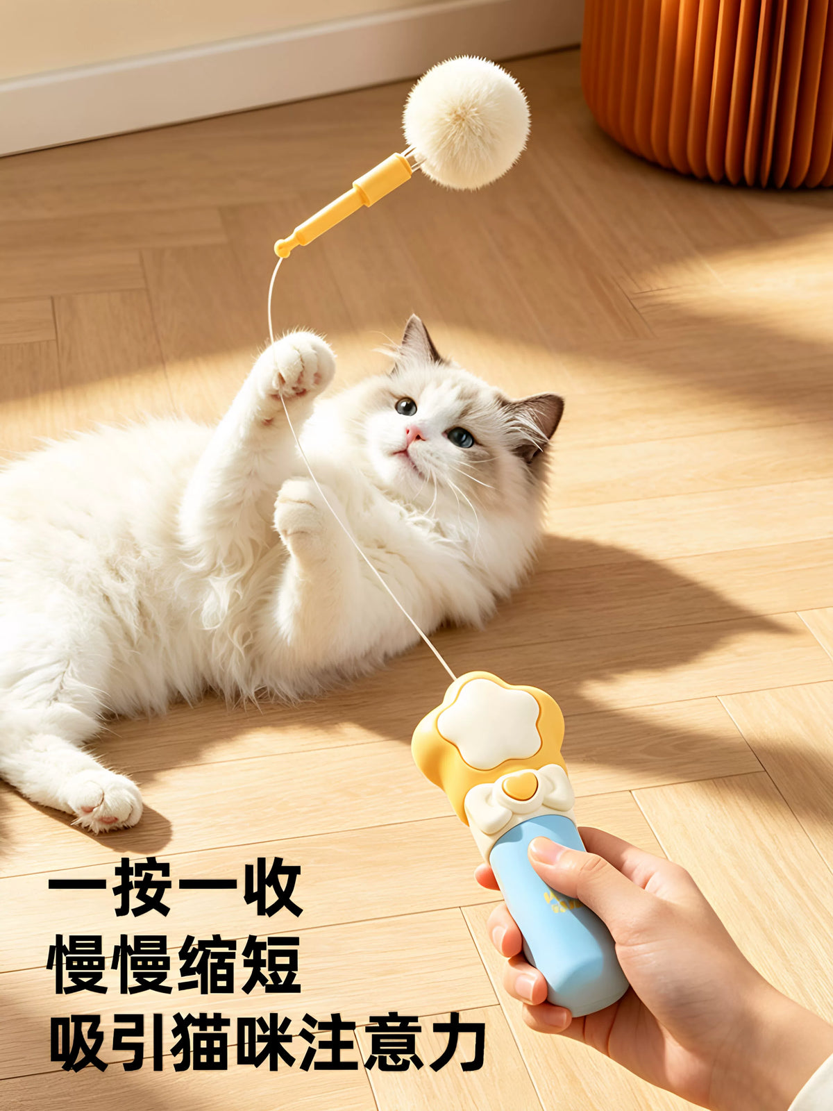 Hand holding the teaser wand while a cat bats at the pom-pom